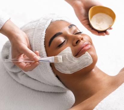 Top view of beauty therapist applying face mask